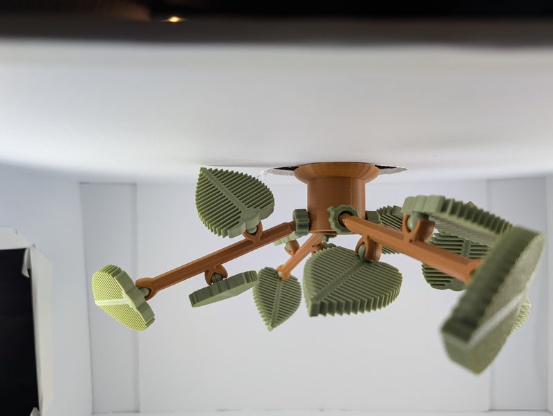 Assembled Egg Tree hanging from a bin lid — terracotta entrance pod with green corrugated leaves where black soldier flies lay eggs